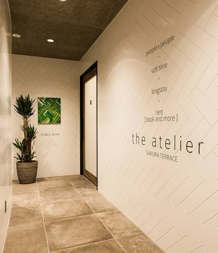 壁にサクラテラスザ・アトリエと書かれた大浴場へ向かう廊下
