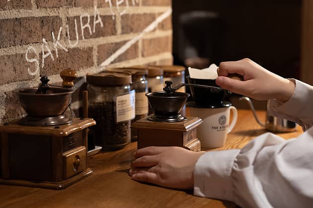 フリーカフェでコーヒー豆をひく女性の手