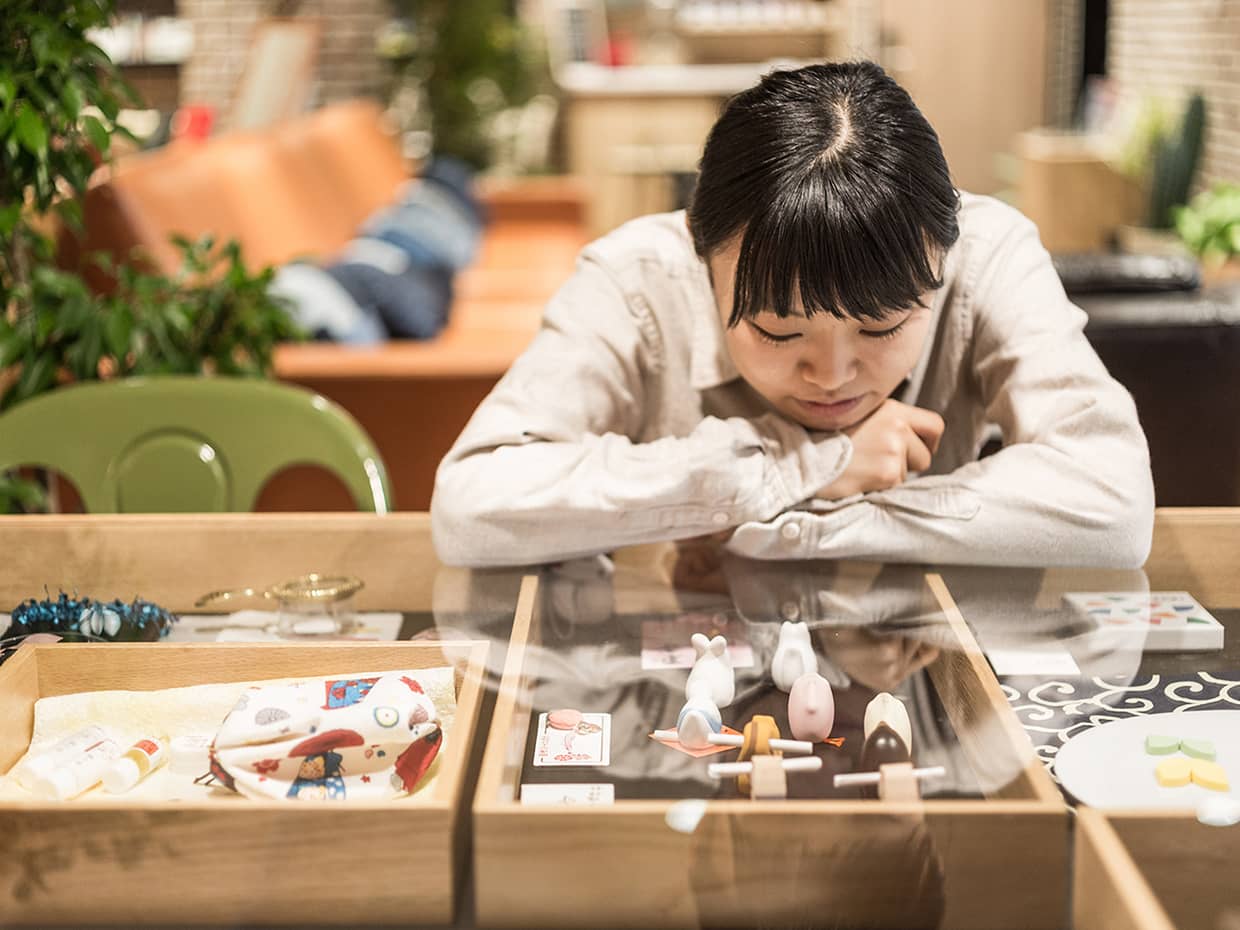 テーブルの創作品を眺める女性