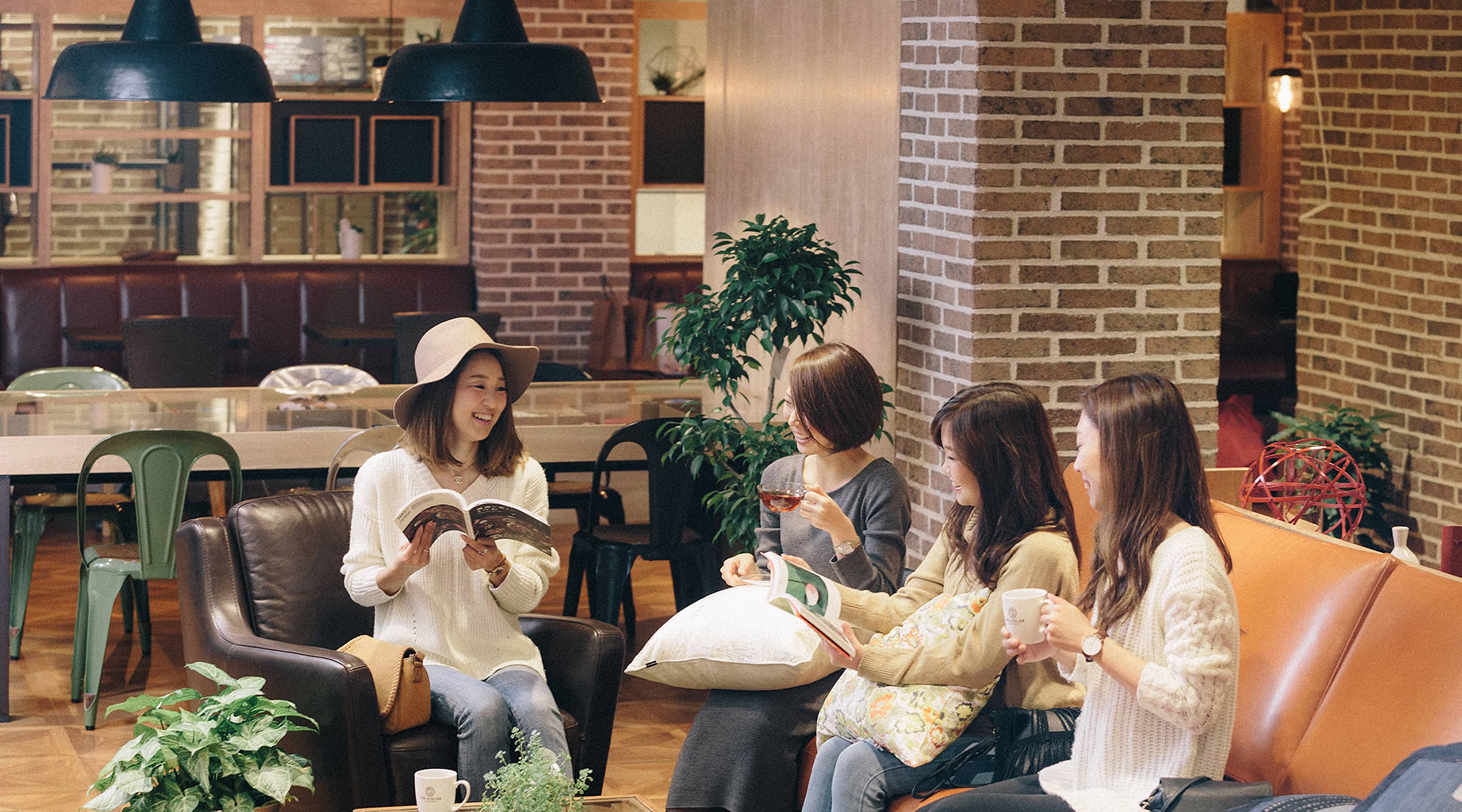 ラウンジで本を片手に会話する４人の女性